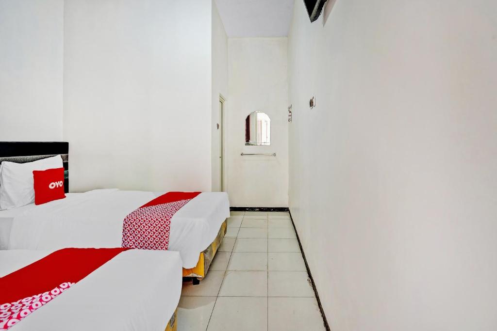 Postel nebo postele na pokoji v ubytování Hotel Kalimantan Surabaya Syariah
