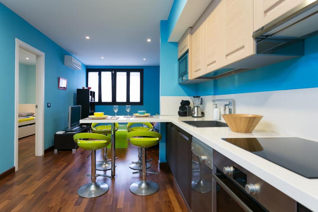 a kitchen with blue walls and green bar stools at La Laguna Centro in Las Lagunas