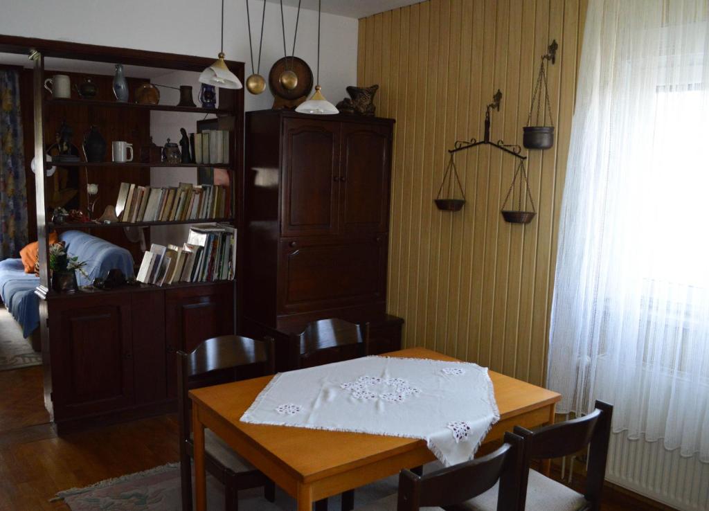 una sala da pranzo con tavolo e libreria di Bibinje Apartment a Bibinje (Bibigne)