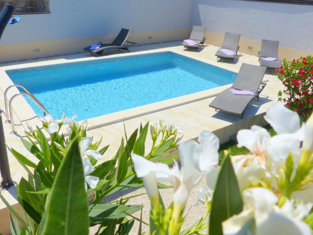 a swimming pool with chairs and flowers in a room at Cozy Holiday Home in Valtura with Swimming Pool in Valtura