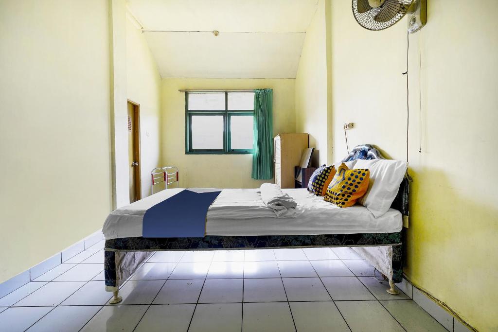 Una cama o camas en una habitación de SPOT ON 91064 Wisma Lec Syariah