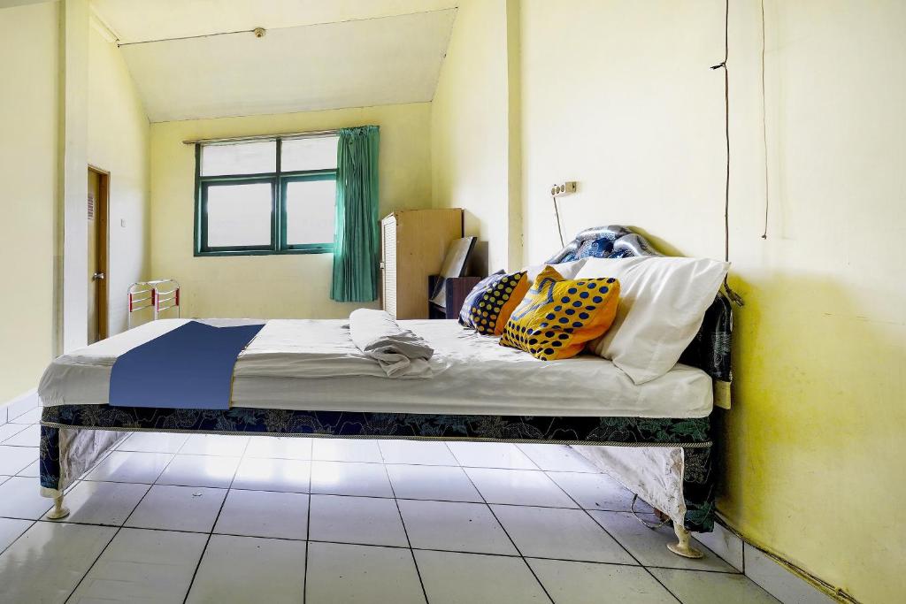 Una cama o camas en una habitación de SPOT ON 91064 Wisma Lec Syariah