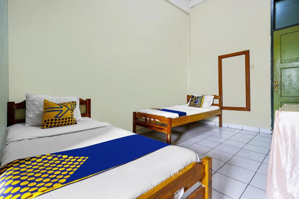 Una cama o camas en una habitación de SPOT ON 91064 Wisma Lec Syariah