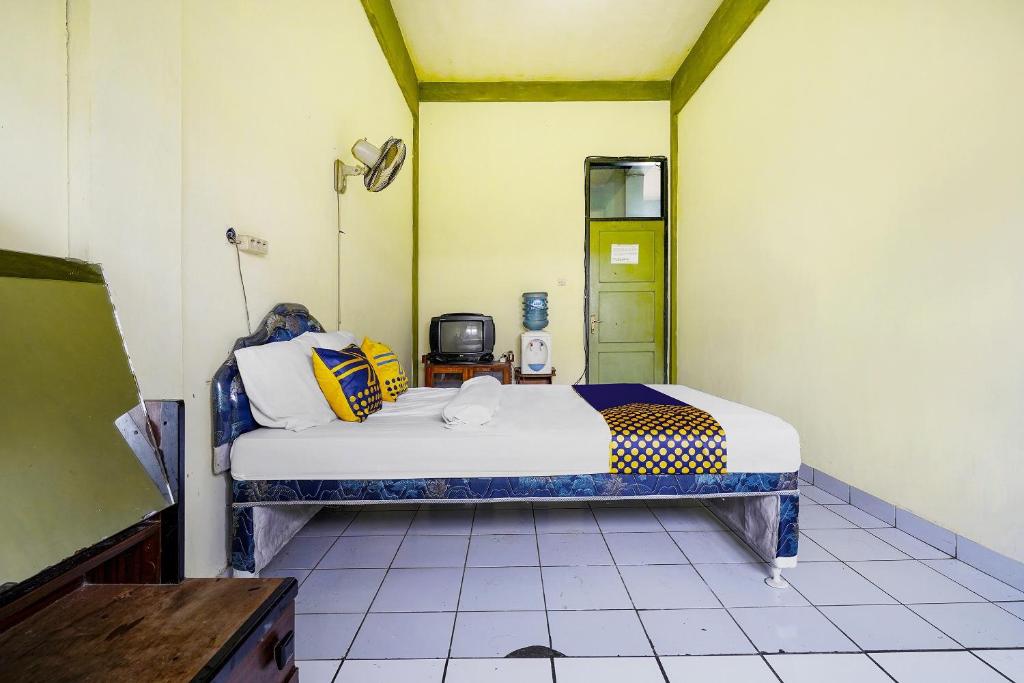 Una cama o camas en una habitación de SPOT ON 91064 Wisma Lec Syariah