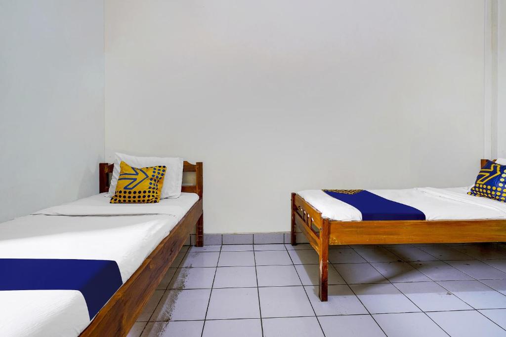 Una cama o camas en una habitación de SPOT ON 91064 Wisma Lec Syariah
