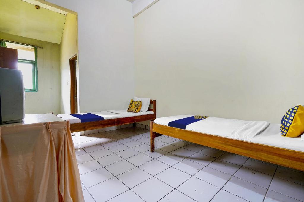 Una cama o camas en una habitación de SPOT ON 91064 Wisma Lec Syariah