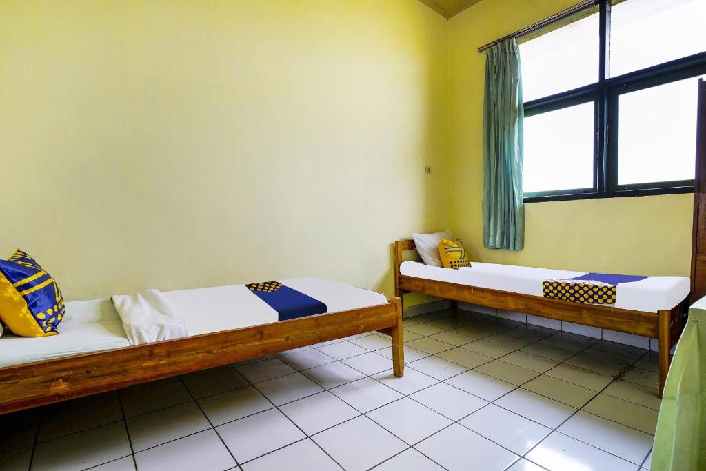 Una cama o camas en una habitación de SPOT ON 91064 Wisma Lec Syariah