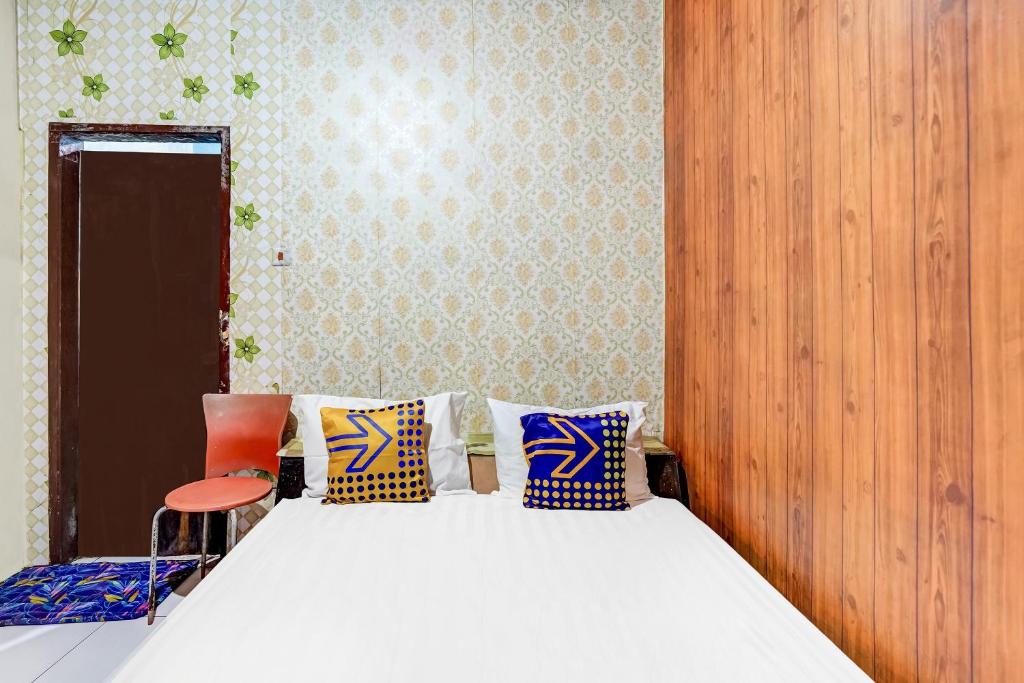 a bedroom with a bed and a chair at OYO Life 91060 Villa Wijaya Homestay in Pasuruan