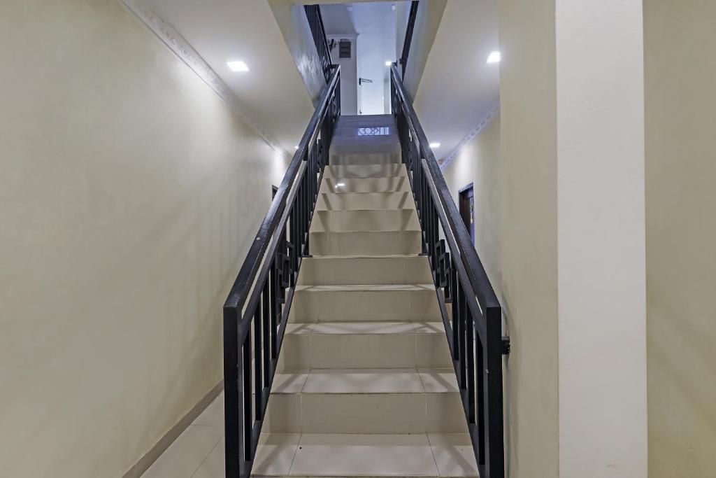 eine Treppe in einem Gebäude mit einem Treppenhaus in der Unterkunft OYO 90981 X2 Homestay in Nagoya