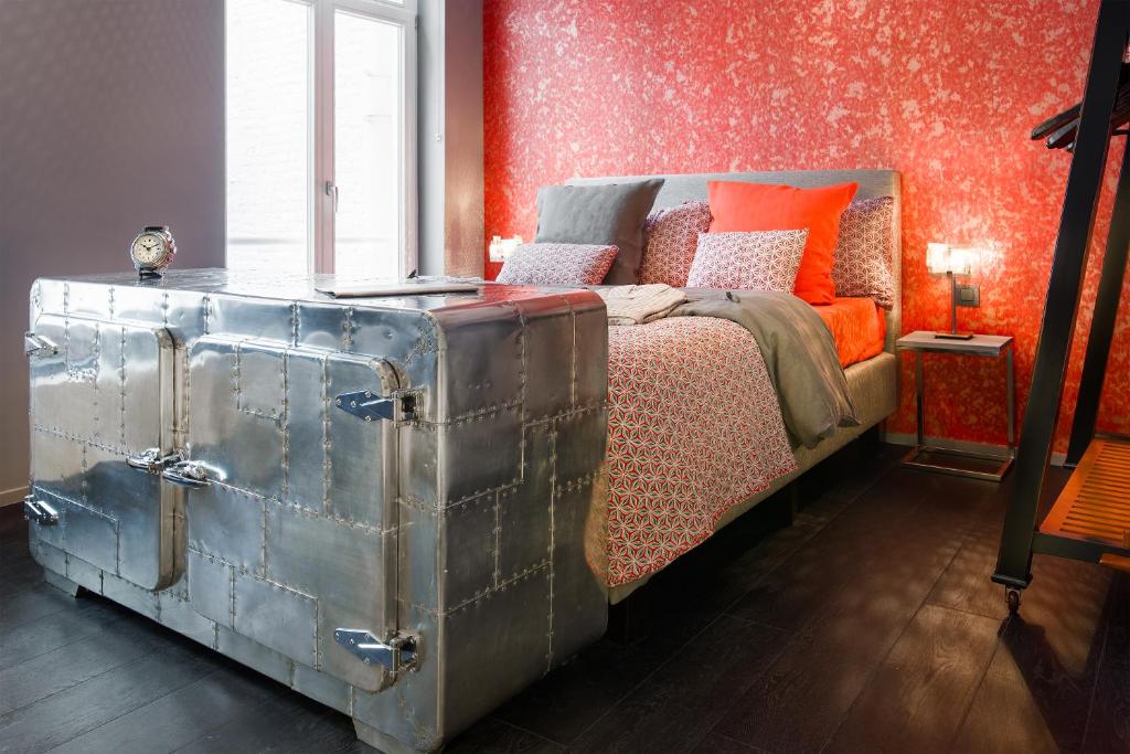 un dormitorio con una cama con un baúl al lado en All In One, en Bruselas