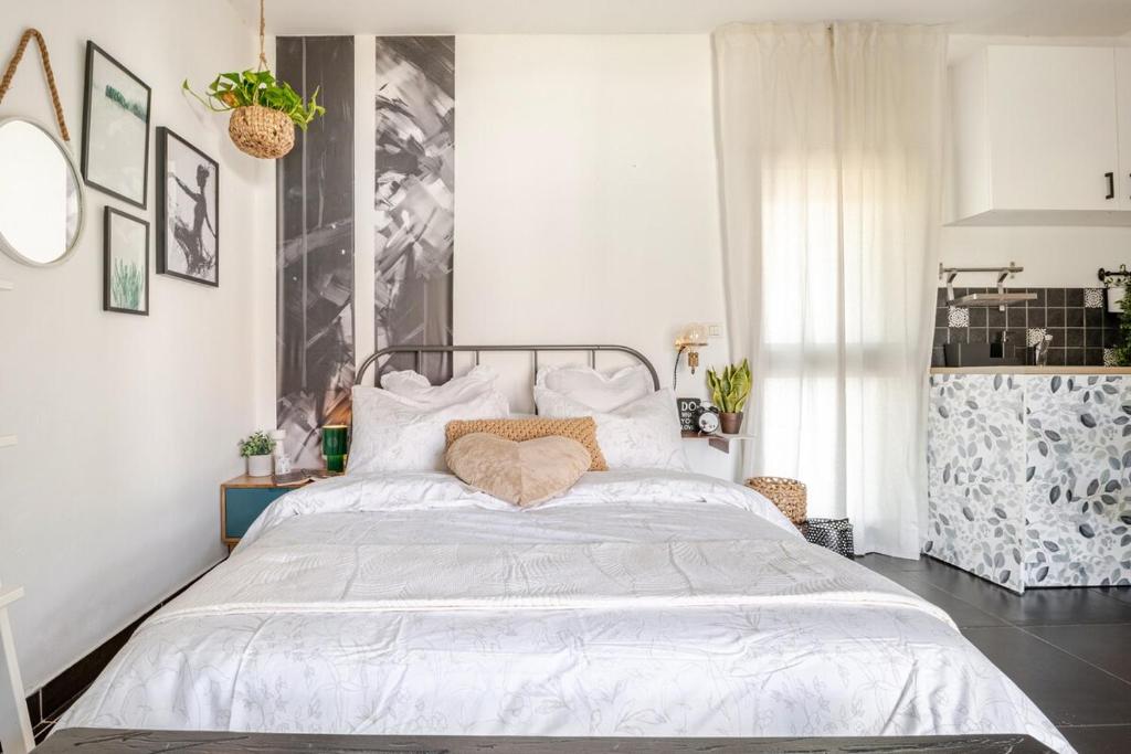 ein Schlafzimmer mit einem großen Bett mit weißer Bettwäsche in der Unterkunft Cozy Givat Ada Countryside Stay in Giv‘at ‘Ada