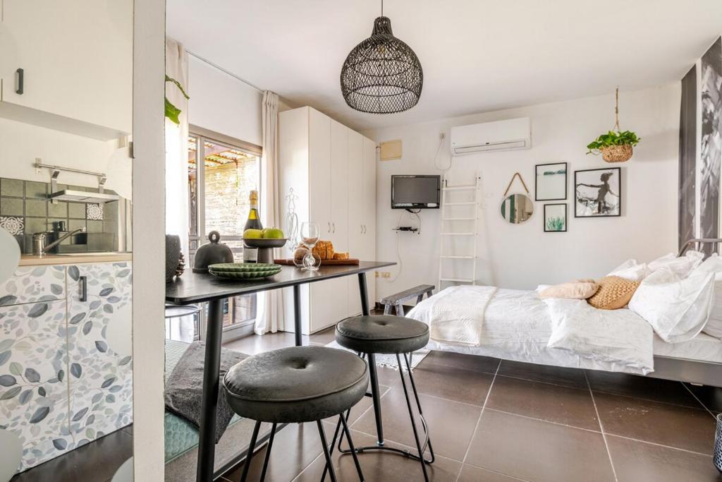 een slaapkamer met een bed en een tafel en stoelen bij Cozy Givat Ada Countryside Stay in Giv‘at ‘Ada