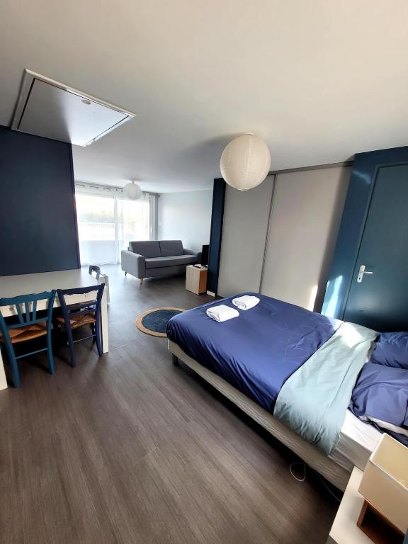 une chambre avec un lit, un bureau et un canapé dans l'établissement Studio indépendant à 5 minutes du Puy DuFou, à Chambretaud