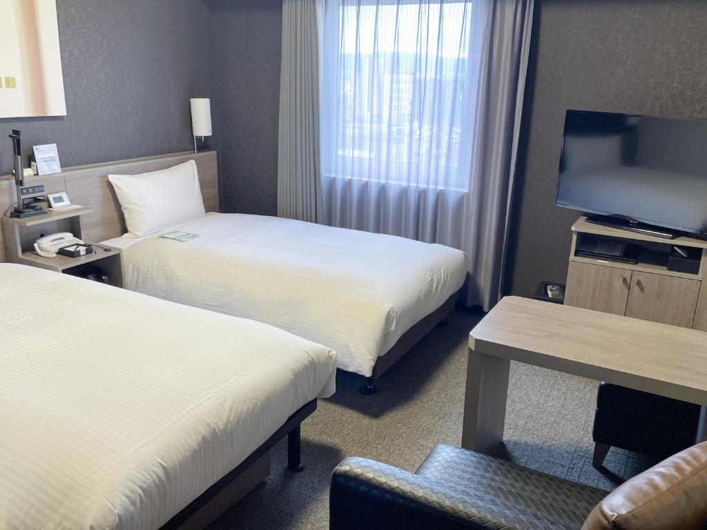Postel nebo postele na pokoji v ubytování Hotel Route-Inn Takefu Inter