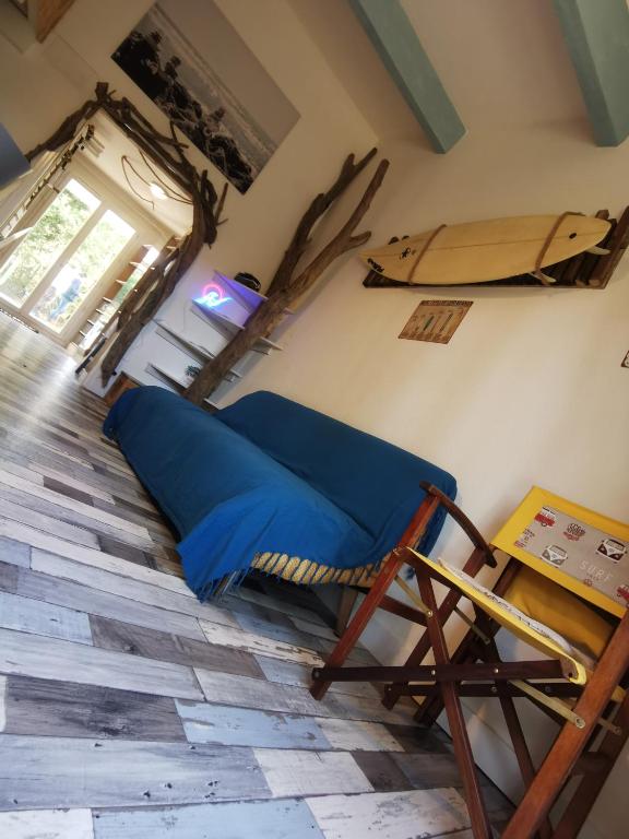 Cette chambre comprend un lit bleu et une chaise. dans l'établissement Cabane de la Glisse, à Lacanau
