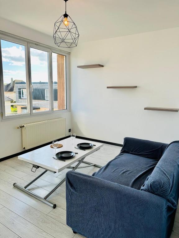 un salon avec une table et un canapé dans l'établissement Appartement spacieux à Caen, à Caen