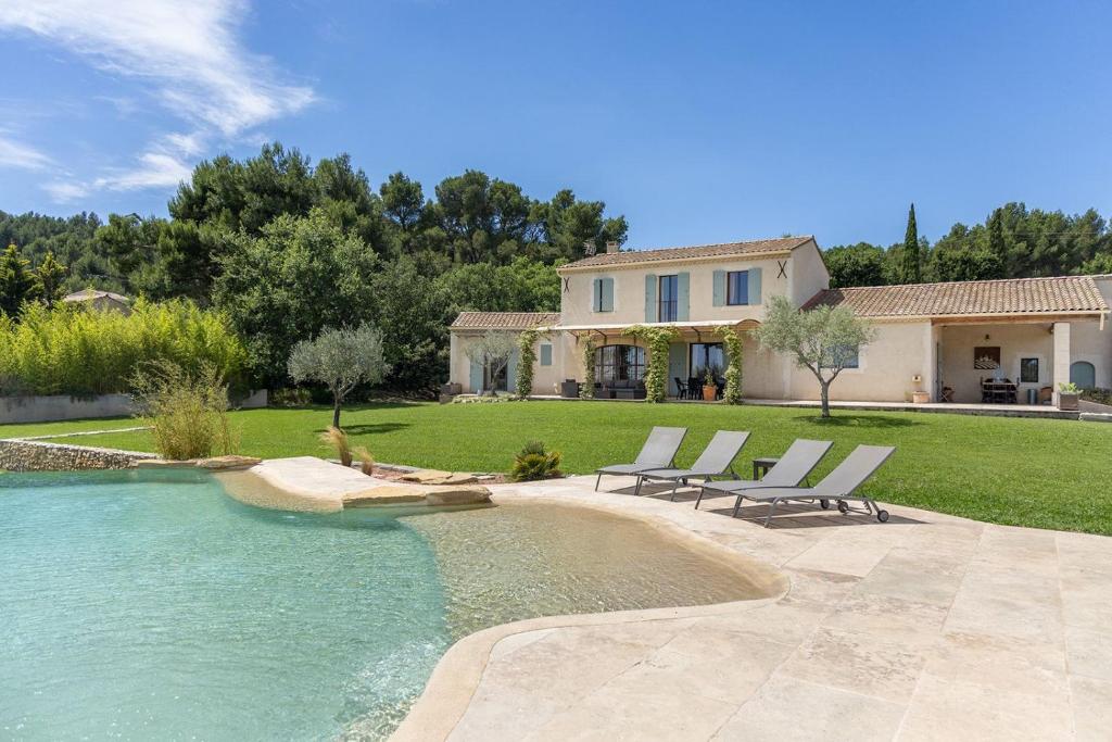 une maison avec une piscine et des chaises dans une cour dans l'établissement Maison style mas « le rougadou », à Noves