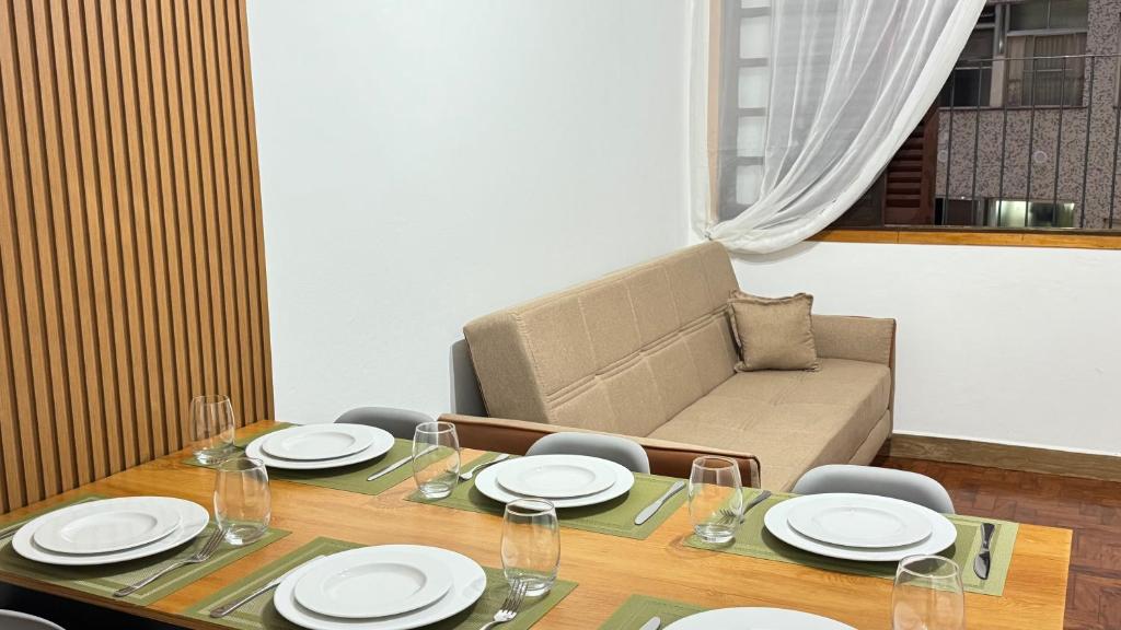 a dining room with a table and a couch at Apto no Centro de SN Pé na Praça in Serra Negra