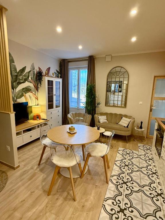 une cuisine et un salon avec une table et des chaises dans l'établissement L Écrin Rémois, à Reims