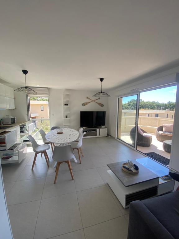 un salon avec une table et des chaises et une cuisine dans l'établissement Le Refuge du Plongeur - Appartement, à Saint-Mandrier-sur-Mer