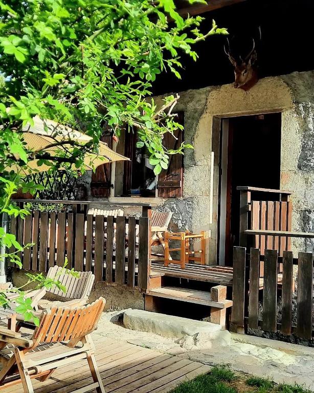 dwa krzesła siedzące na drewnianym tarasie z domem w obiekcie La cabane de Blanche entre lac et montagne w mieście Verchères