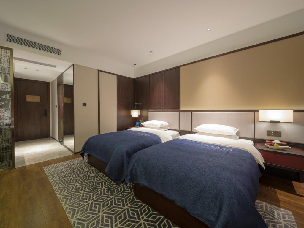 Zhengzhou East Station Longzi Lake University Area Qianna Yuanxi Hotel客房内的一张或多张床位
