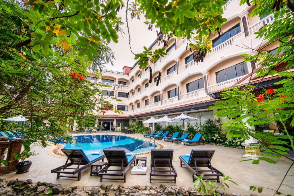 a hotel with a swimming pool and lounge chairs at Khemara Angkor Hotel & Spa in Siem Reap