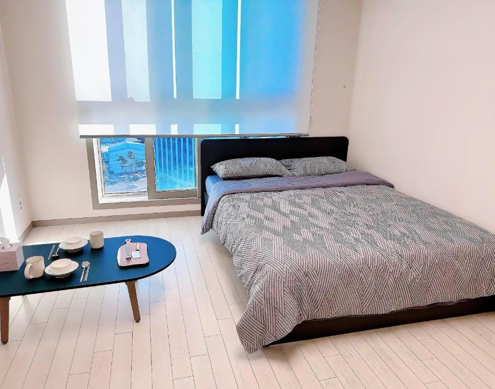 een slaapkamer met een bed, een tafel en een raam bij DDMOP-Seoul in Seoul