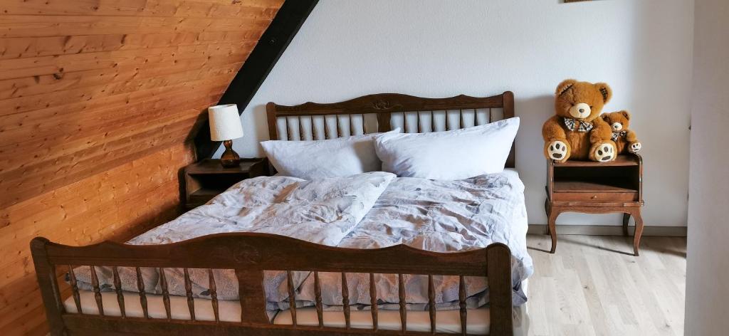 - une chambre dotée d'un lit avec un ours en peluche sur une table dans l'établissement Gemütliches Ferienreihenhaus mit Holzkamin im Schwarzwald, à Bernau im Schwarzwald