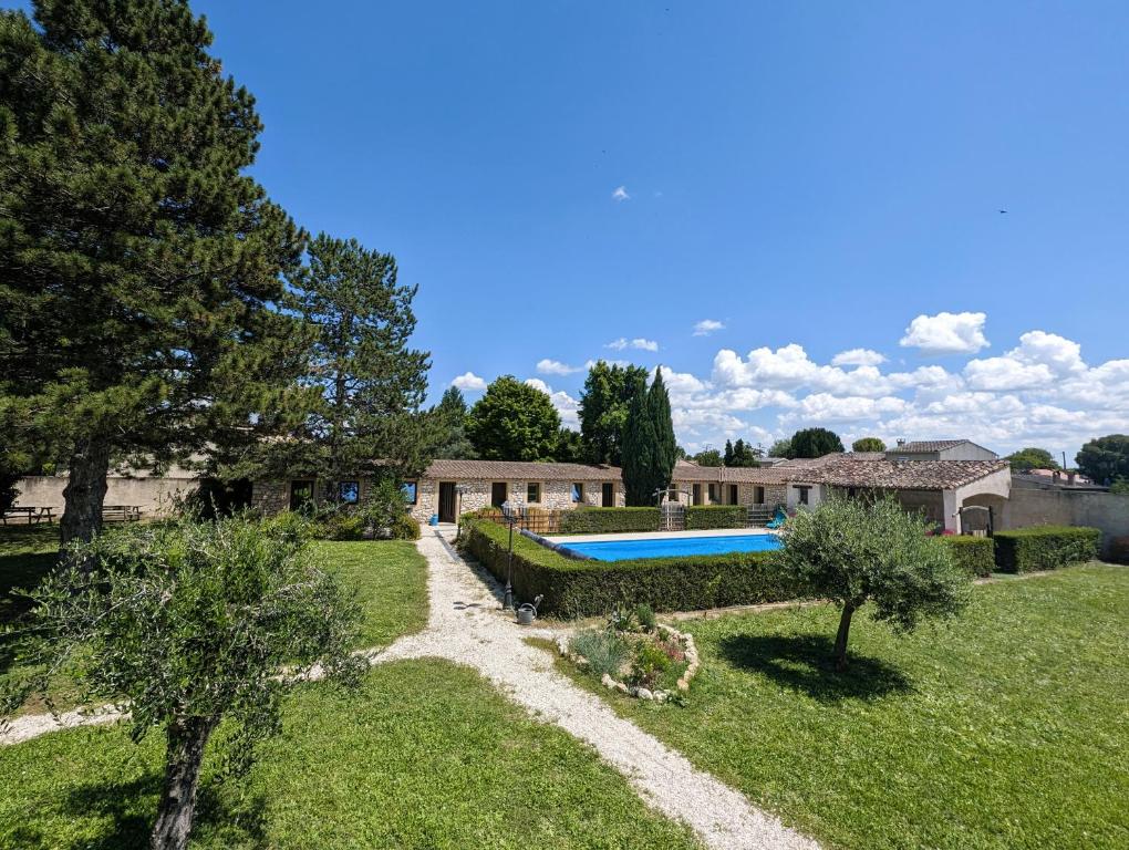 une maison avec une piscine dans une cour dans l'établissement La Bottellie - Gîtes & chambres d'hôtes entre Cévennes et Camargue, à Saint-Géniès-de-Malgoirès