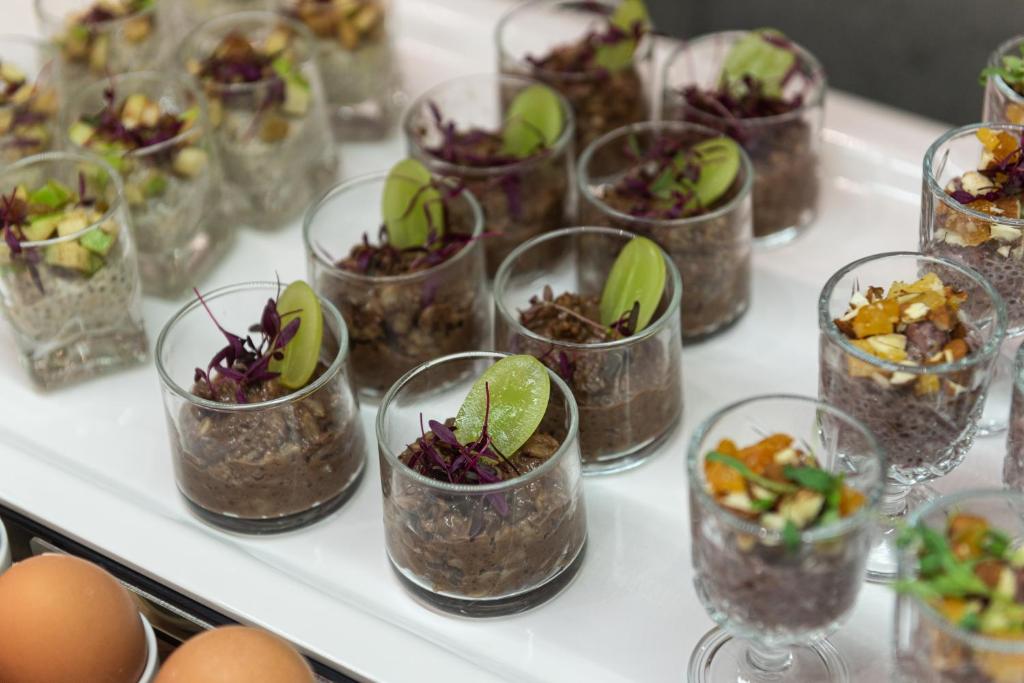 a buffet filled with glasses filled with plants and eggs at Rise Urban Art Hotel in Larnaca