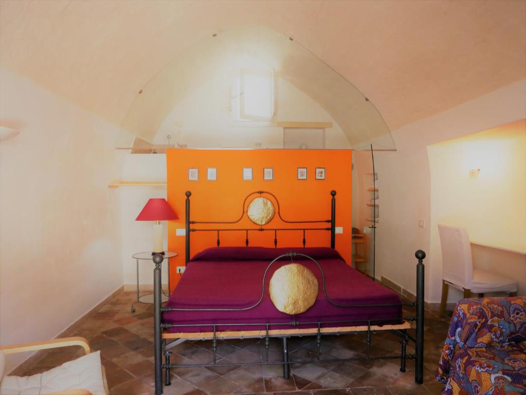 a bedroom with a bed with an orange head board at Casa della Luna in Matera