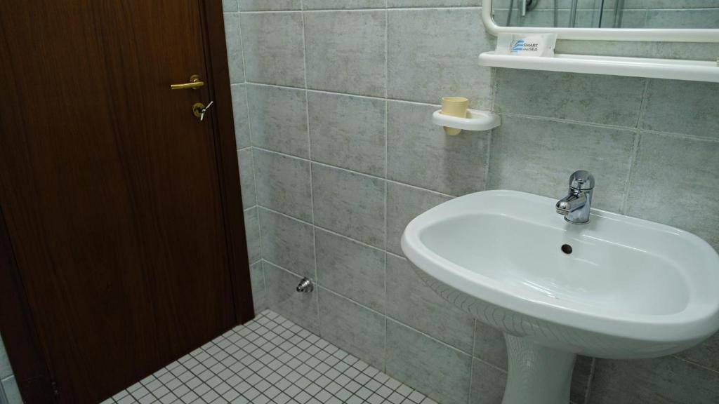 a bathroom with a white sink and a toilet at Smart and Sea in Tortoreto Lido