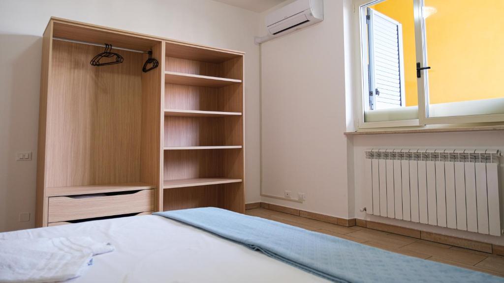 a bedroom with a bed and a window and shelves at Smart and Sea in Tortoreto Lido