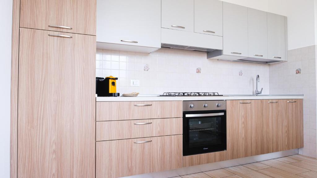 a kitchen with wooden cabinets and a stove top oven at Smart and Sea in Tortoreto Lido