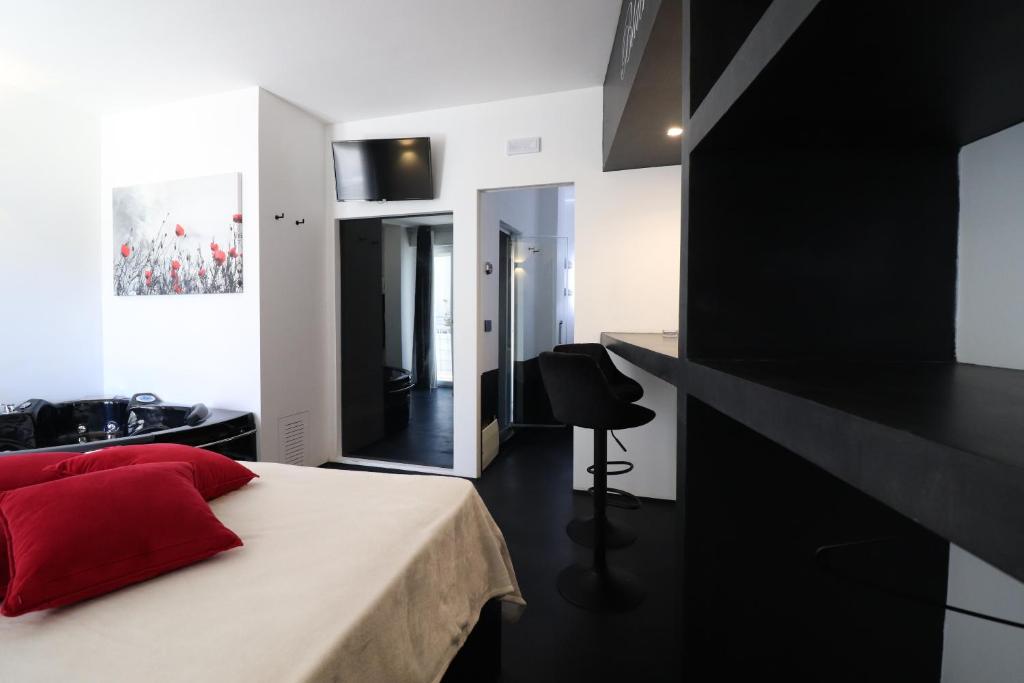 een zwart-witte slaapkamer met een rood kussen op een bed bij Suite Black and White in Otranto