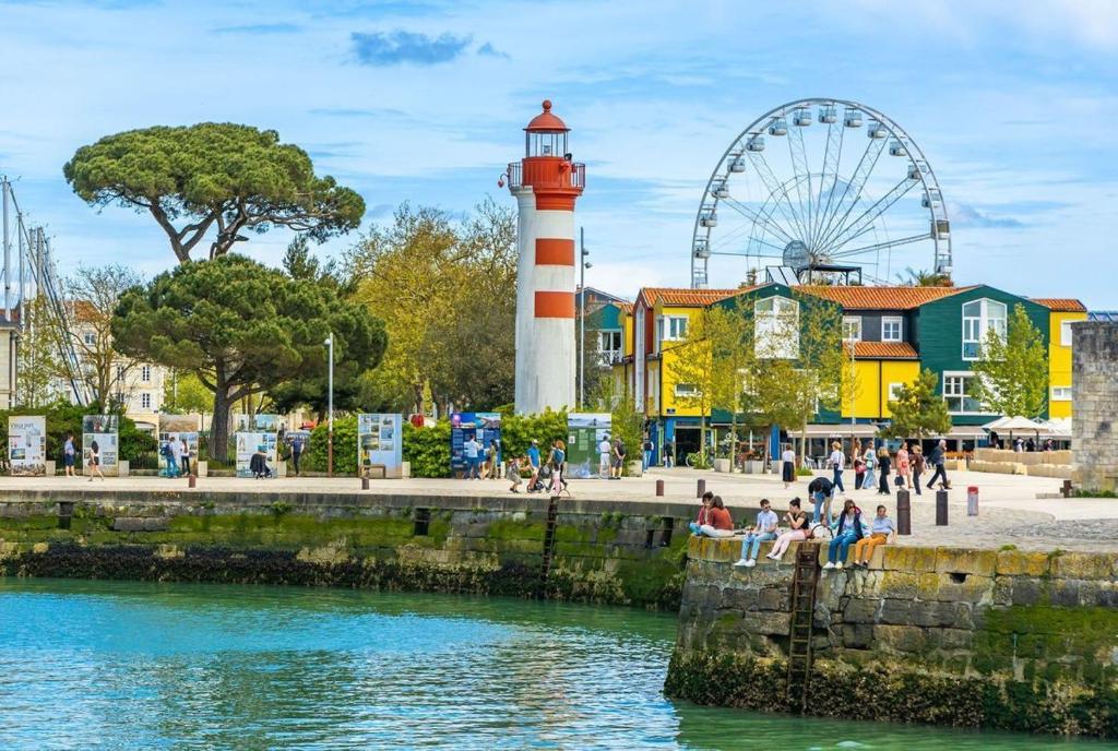 un phare et une grande roue à côté d'un plan d'eau dans l'établissement Grand studio a 2 pas du vieux port, quartier Gabut, à La Rochelle