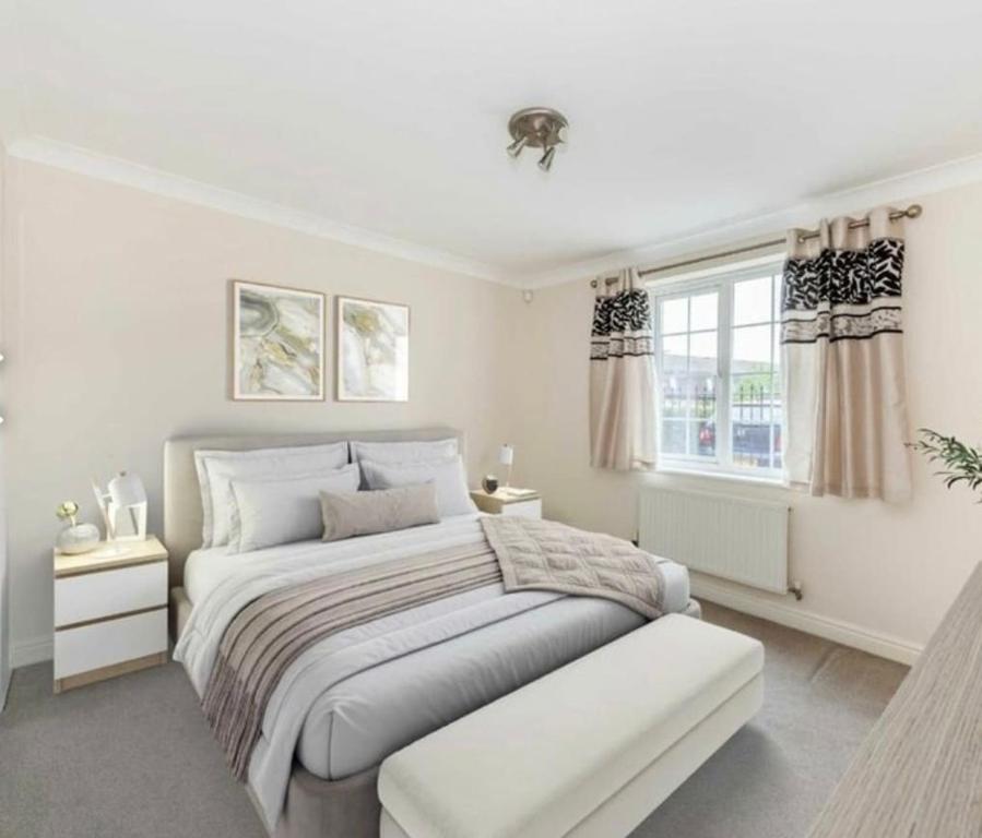 a white bedroom with a bed and a window at Spacious 2-Bed Family Flat in Wimbledon Near Tube in London