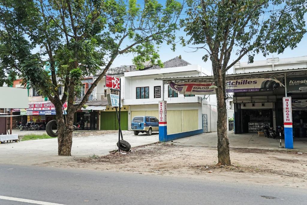 two trees on the side of a street at Hotel O Penginapan Indah Permai Syariah in Tanjungraya