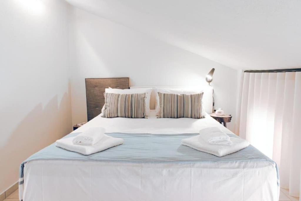 a bedroom with a white bed with two towels on it at Ona Boutique Apartments in Hanioti
