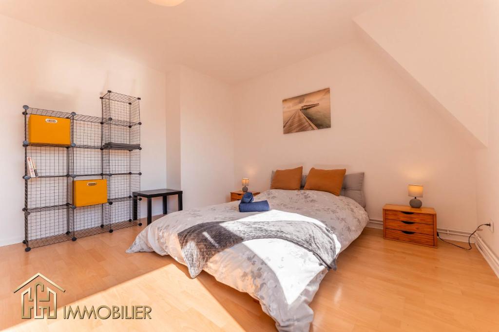 une chambre avec un grand lit et un parquet dans l'établissement Appartement L'Orient - Parking, à Colmar
