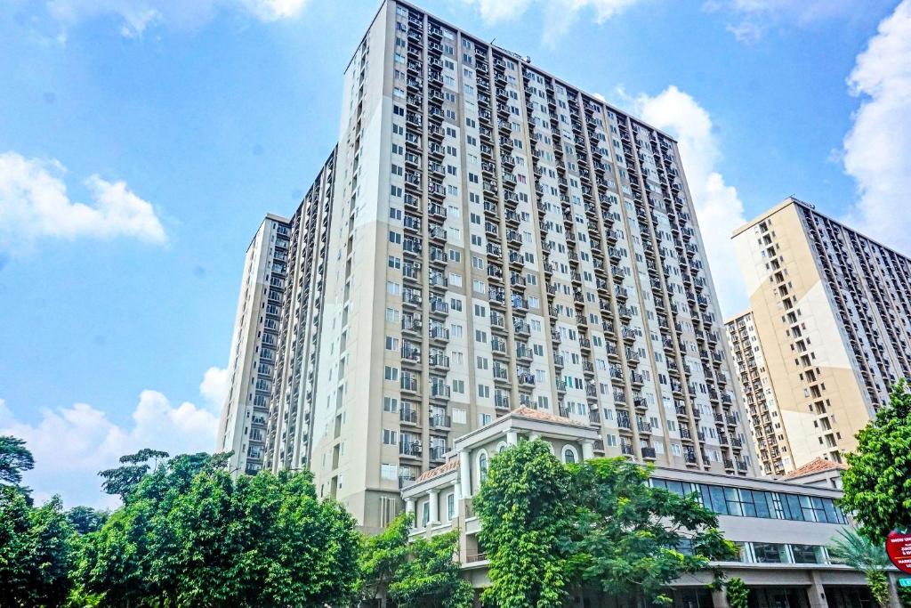 un grande edificio bianco con alberi di fronte di OYO 91217 Skyland @ Pgv Near Gunung Putri a Taladjurg-udik