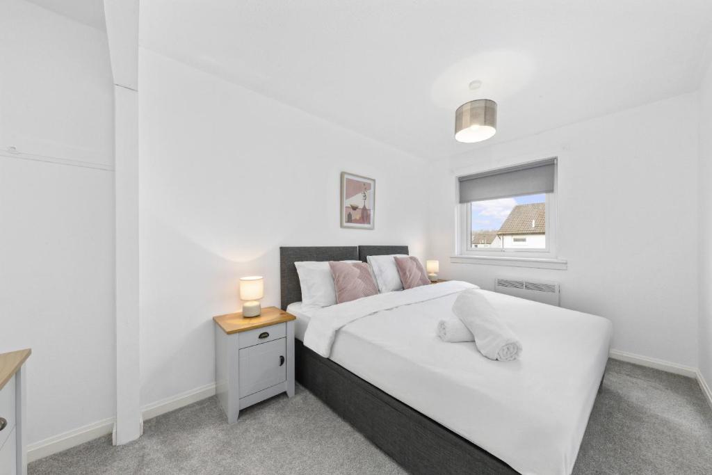 a white bedroom with a bed and a window at 1-Bed Home in Lanarkshire with Free Parking - Long Stays Available in Newarthill