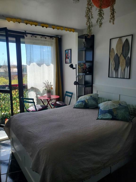 une chambre avec un lit, une table et une fenêtre dans l'établissement Appartement COSY entièrement équipé, à Toulouse