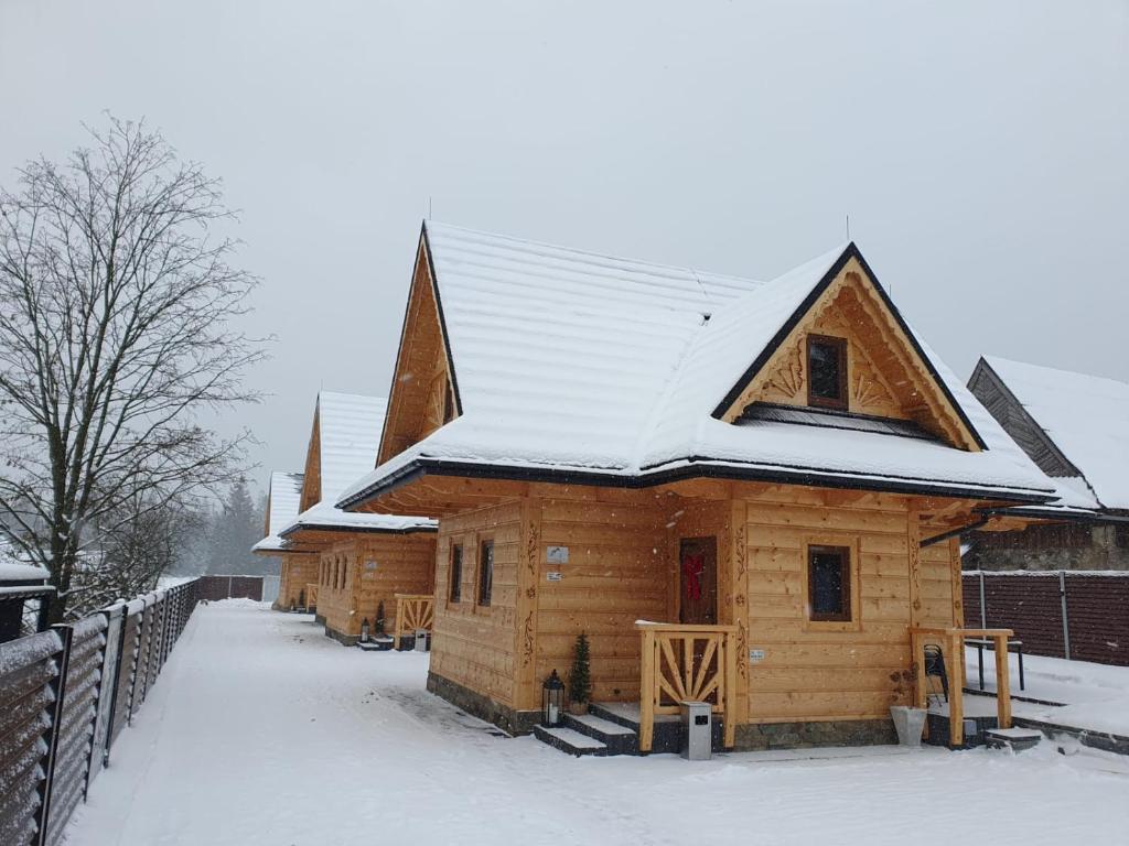 a log cabin with snow on the roof at Osada Bajka in Murzasichle