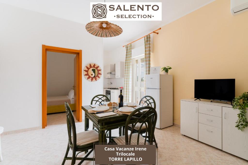 a dining room with a table and chairs and a television at Casa Vacanze Irene - Salento Selection in Torre Lapillo