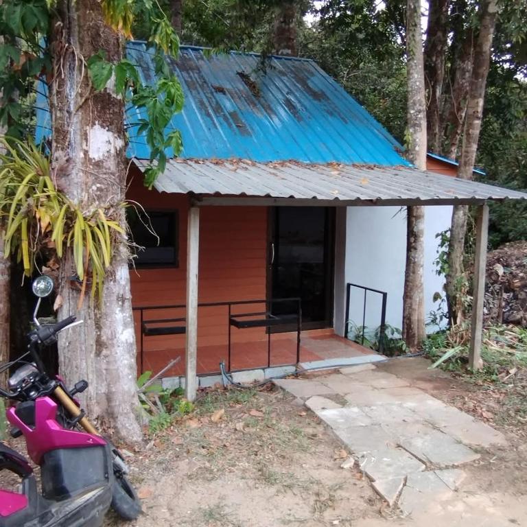 a house with a motorcycle parked in front of it at Phen's House in Ko Chang