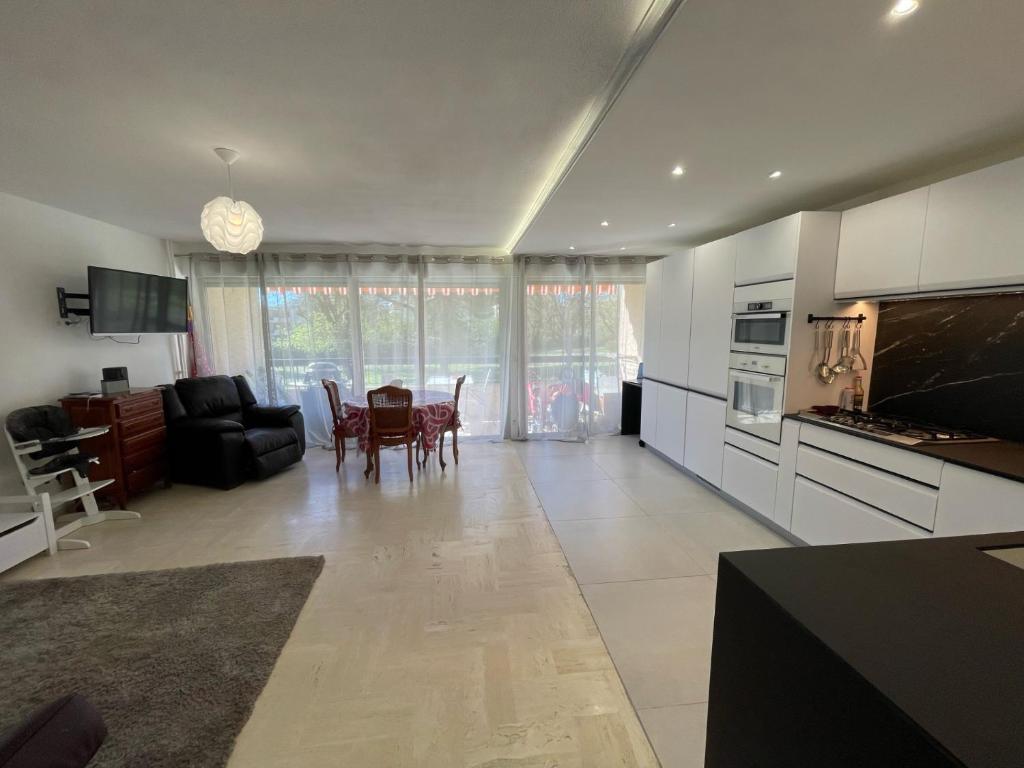 une cuisine et un salon avec une table et des chaises dans l'établissement grand appartement 74m2 refait à neuf à 5mn de la mer dans grand parc botanique, à Villeneuve-Loubet