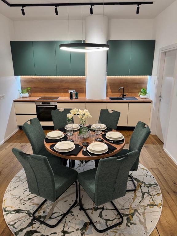 een keuken met een tafel en groene stoelen bij Premium Apartment Koper in Koper