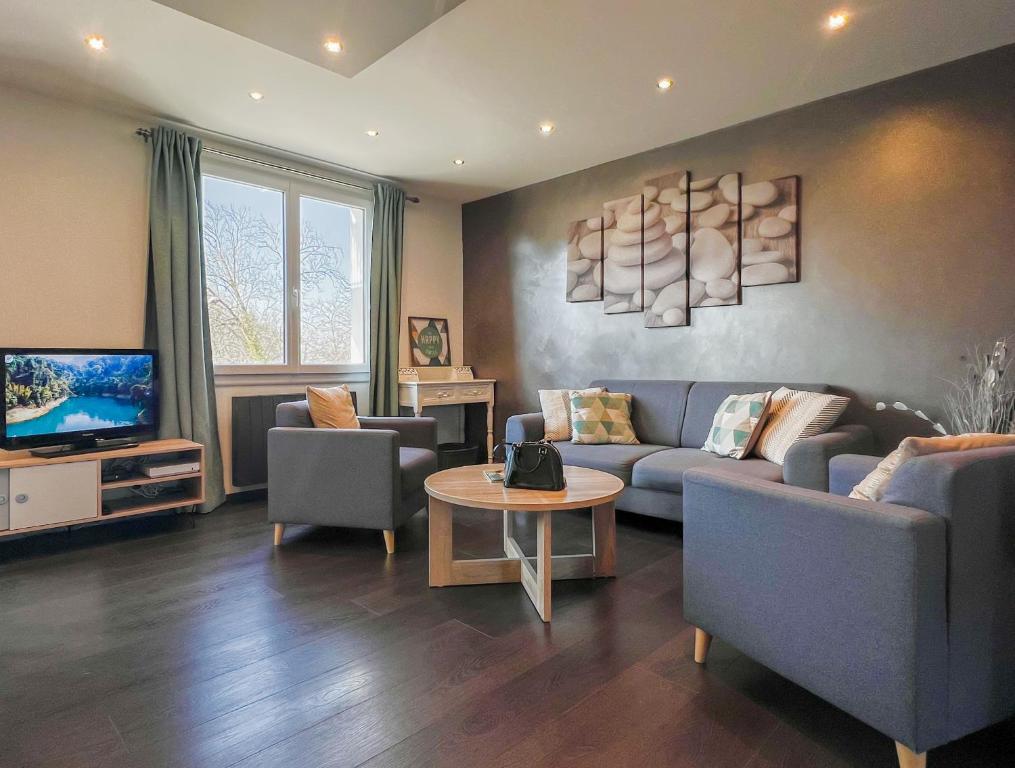 un salon avec un canapé, des chaises et une télévision dans l'établissement Imperial Ember 2 min du lac, à Annecy